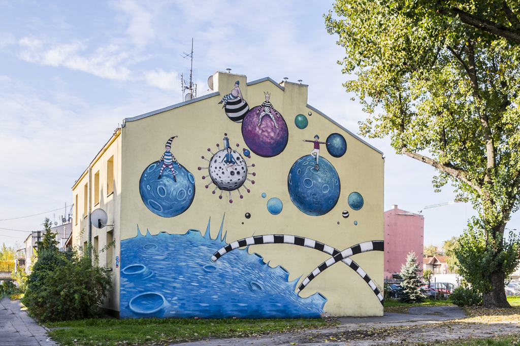 Kolorowy mural namalowany na bocznej ścianie dwukondygnacyjnego budynku