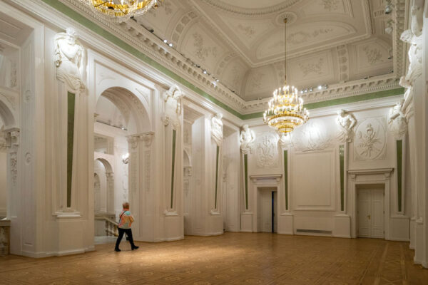 Wnętrza Pałacu Rzeczypospolitej, białe ściany zdobione sztukateriami, w nawach rzeźby wojowników.