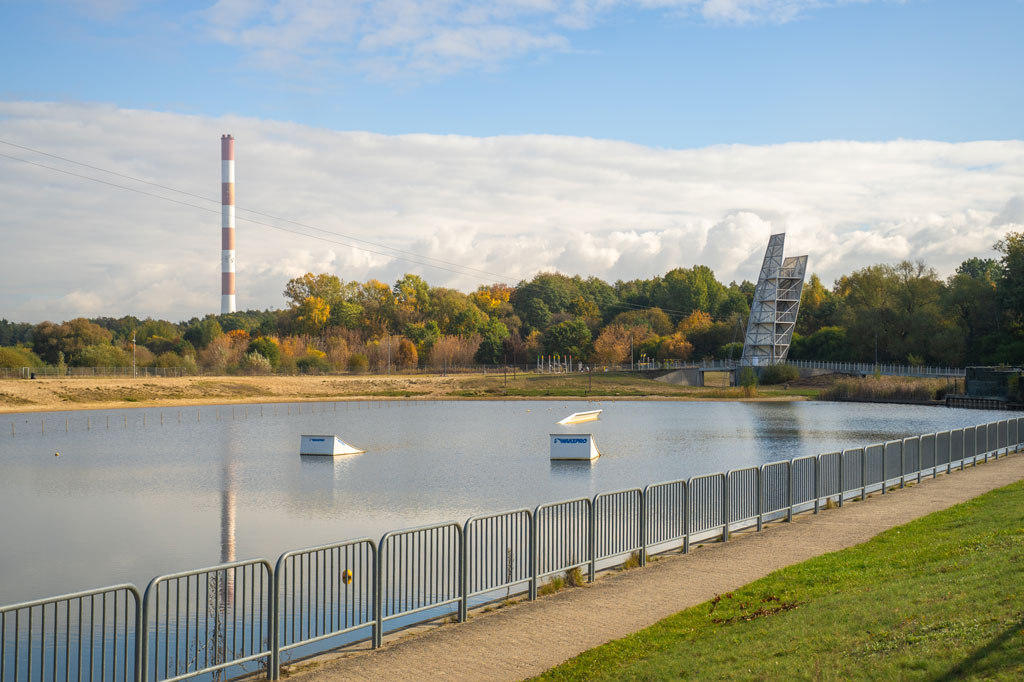 Zalew wodny, na brzegu ustawiona wieża widokowa, dookoła rosną drzewa, dzień, jesień.