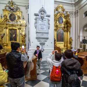Wycieczka japońskich turystów zwiedza Bazylikę Świętego Krzyża, stoją przy kolumnie, w której spoczywa serce Fryderyka Chopina.